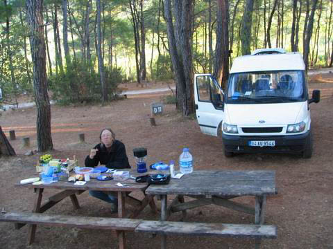 Tom eating Turkish breakfast, gypsy style on a picnic table next to the minivan