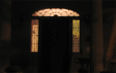 ghostly private home with spider web design in arched doorway window